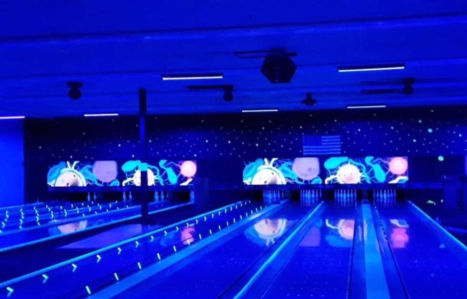 Glow bowling lanes with neon blue lights and LED screens at Newport Entertainment Center
